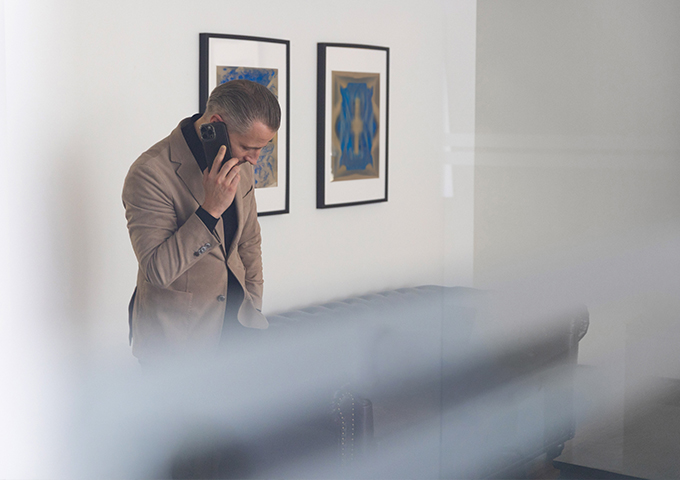 Tim Ehlert telefoniert mit einem Mobiltelefon in einem Büro